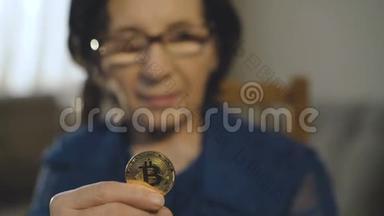 一位老妇人的画像在镜头前拿着一<strong>枚</strong>金色的比特币